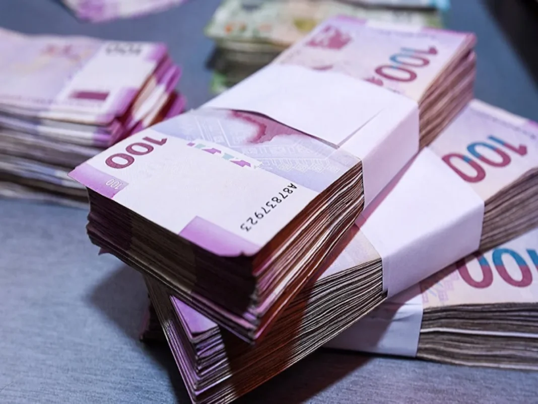 Azerbaijani manat banknotes and coins against the national flag