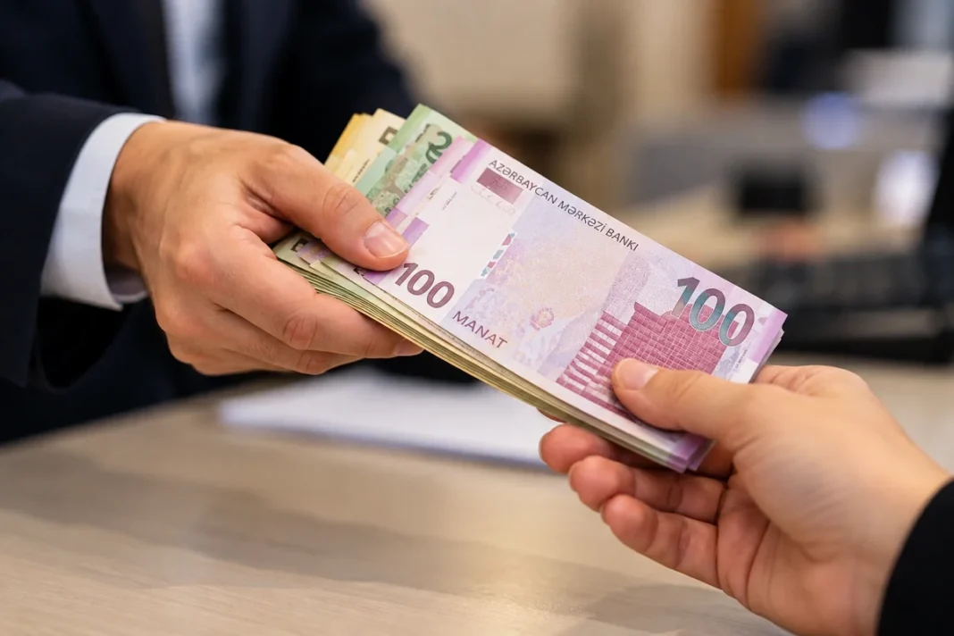 A person hands Azerbaijani manat banknotes across a desk