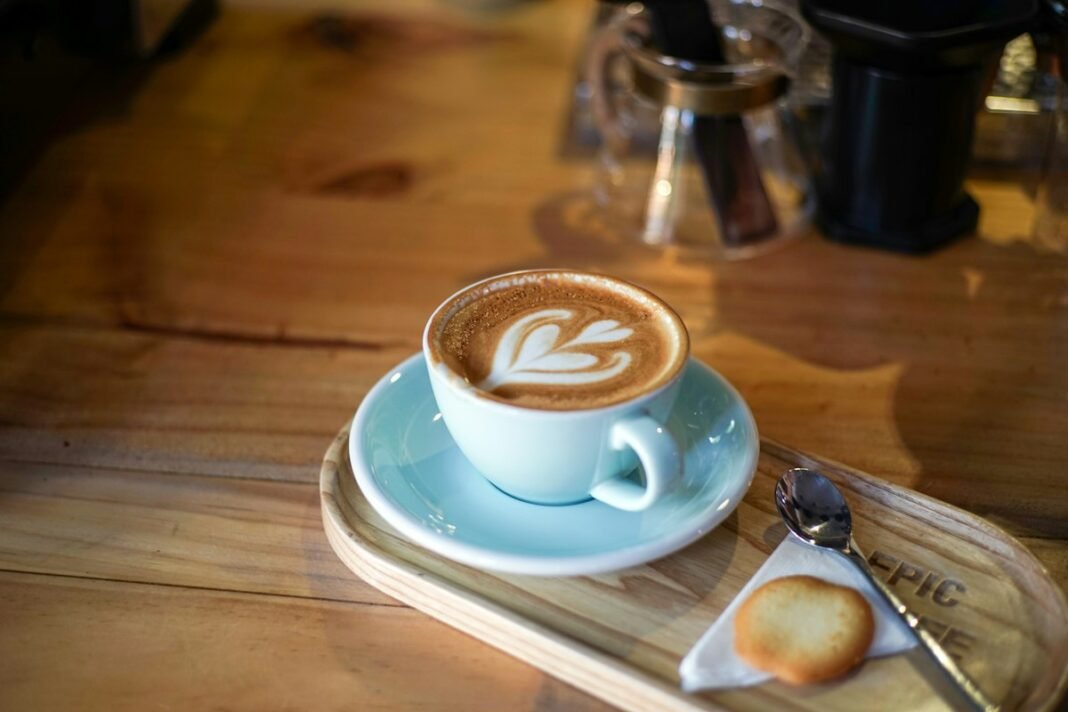 A cup of cappuccino at a cafe. Illustrative photo by Nam Quach via Unsplash.