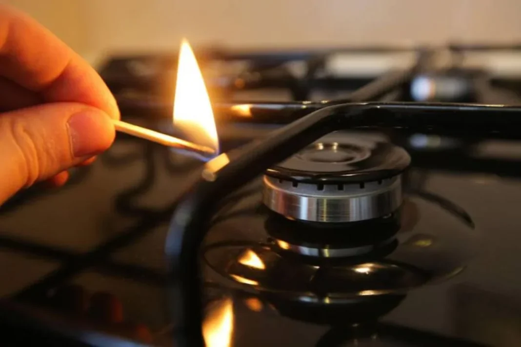 A match being used to light a gas stove burner