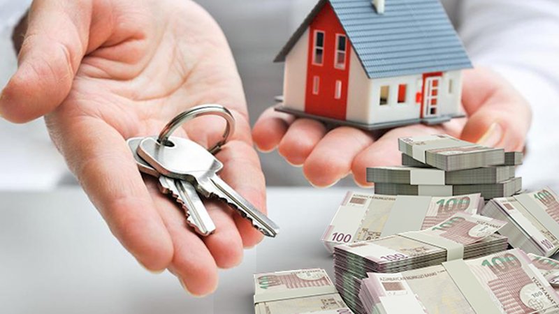 Hands holding house keys and a model home beside stacks of banknotes