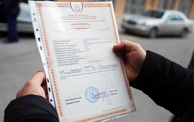 A person holds an Azerbaijani property title extract.