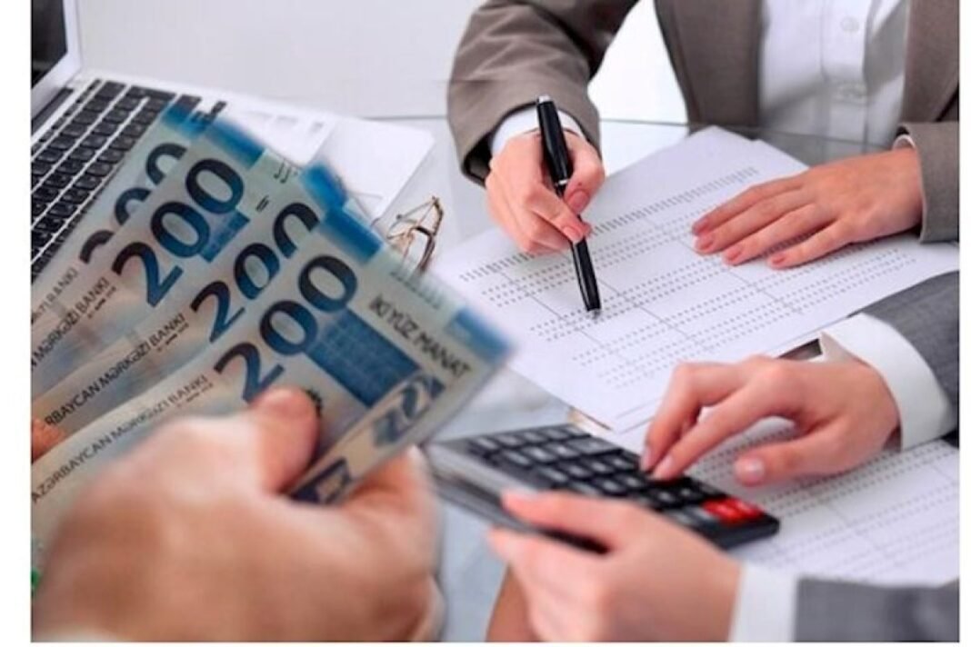 Documents and Azerbaijani manat banknotes illustrating social program funding
