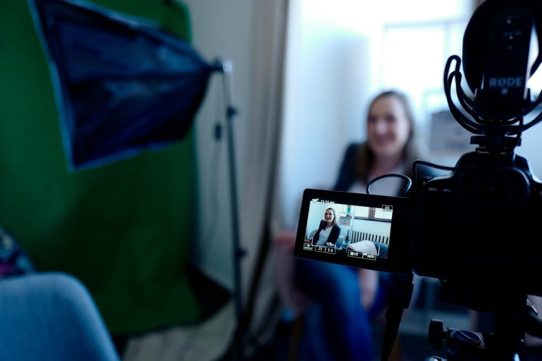 A content creator working in front of a camera and green screen